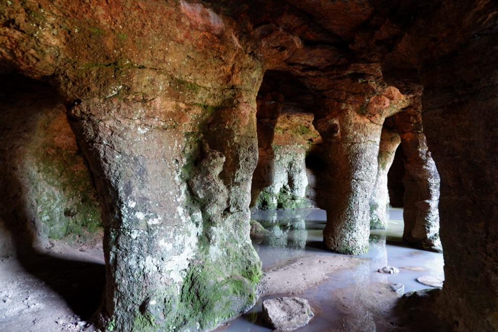 Ein Foto in einer Steinhöhle mit vielen torähnlichen Bögen.