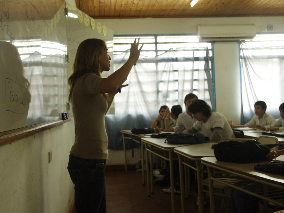 Ein Foto von einer Lehrerin in einem Klassenzimmen mit Jugendlichen.