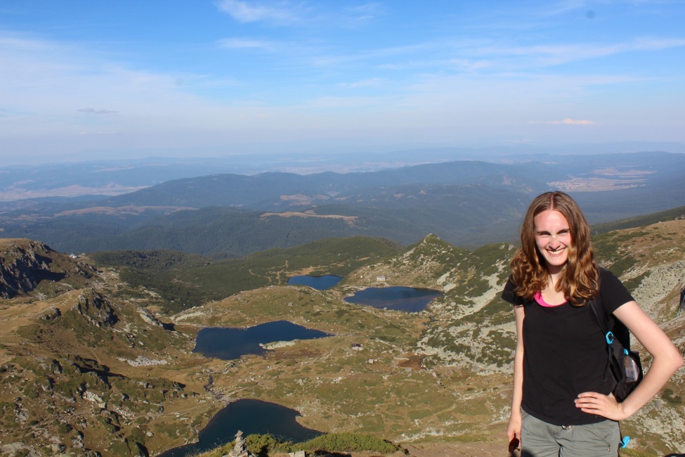 Ein Portraitfoto von der kulturweit-Freiwilligen in einer Berglandschaft.