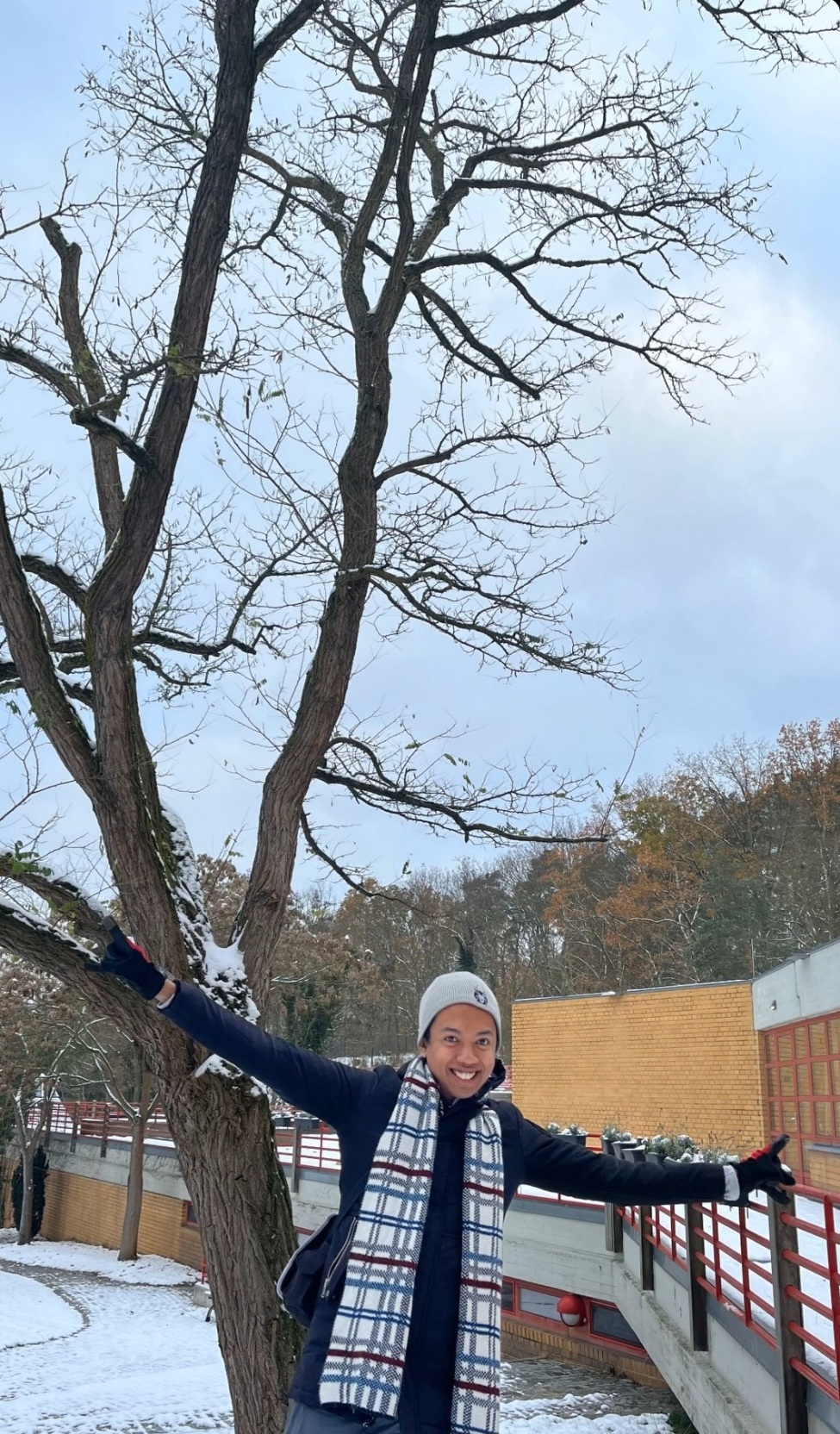 Luciano steht mit ausgebreiteten Armen vor einer verschneiten Landschaft