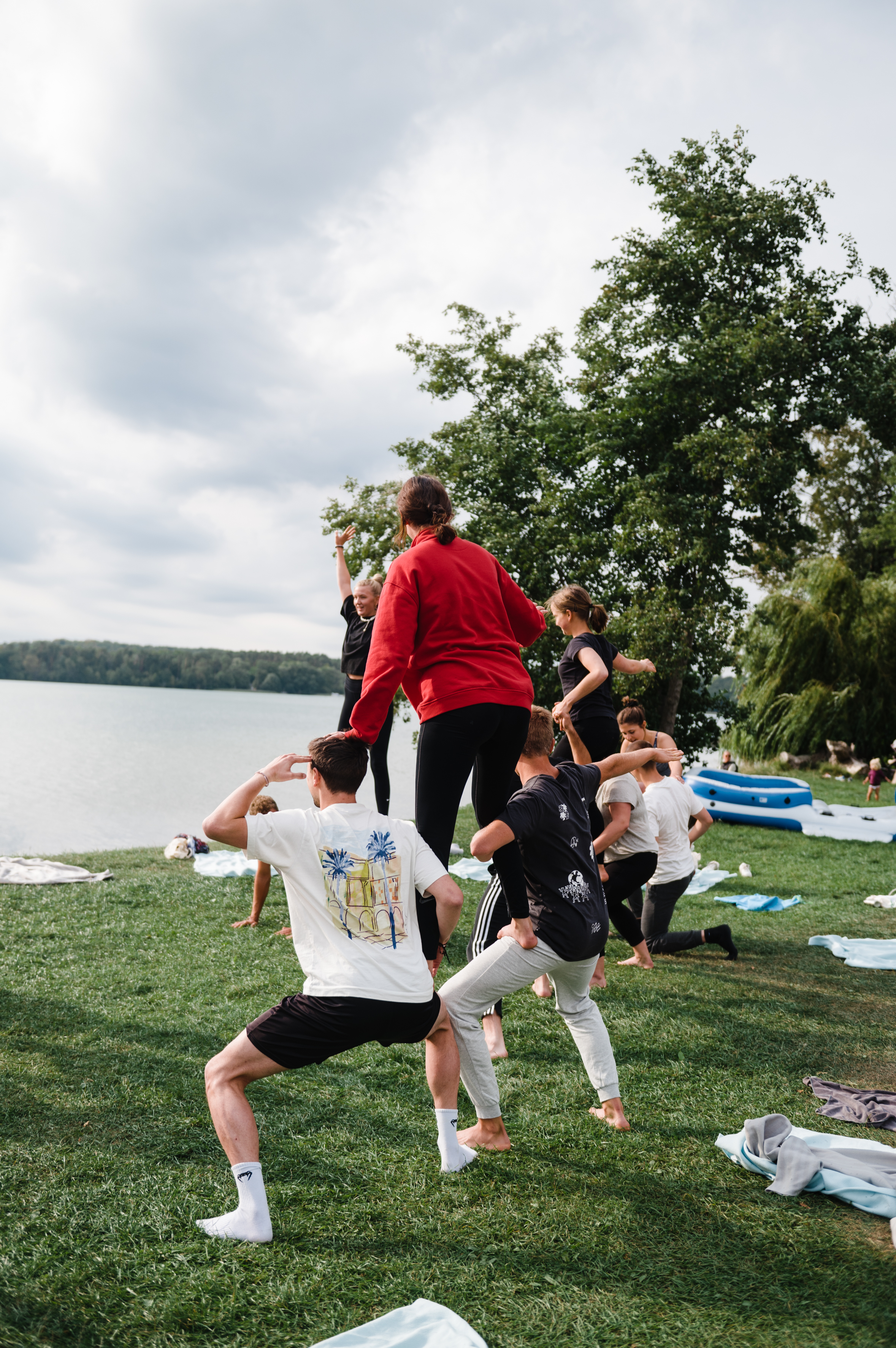 Freiwillige machen eine Menschenpyramide bei einer Teamübung auf dem Vorbereitungsseminar am Werbellinsee.