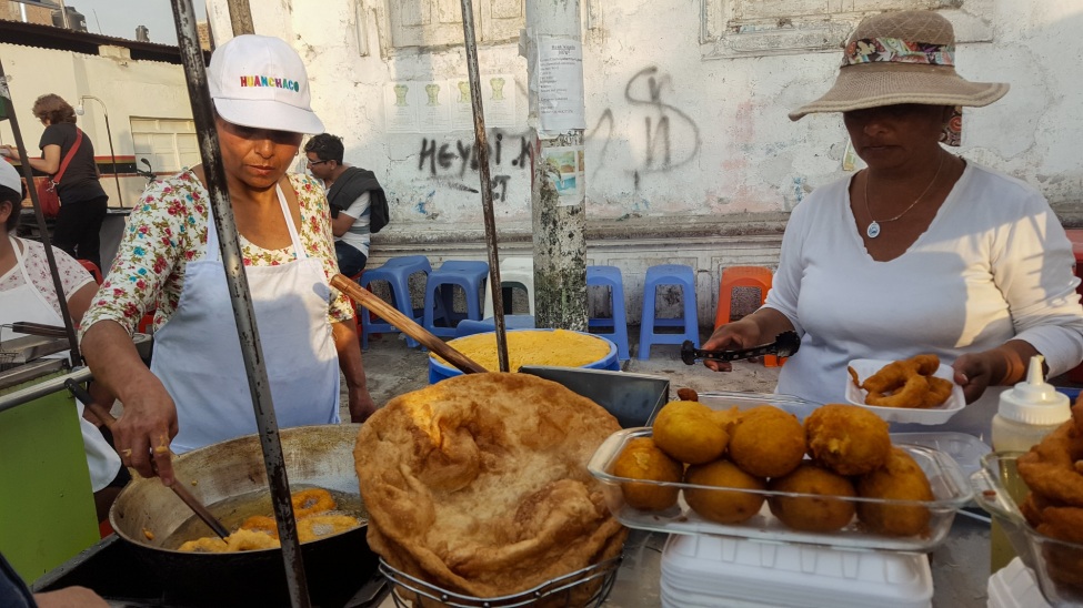 Zwei Personen kochen Essen an einem Marktstand