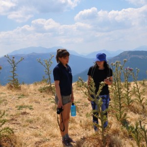 Ein Foto von zwei Personen auf einer vertrockneten Grasebene in den Bergen.