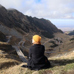 Angelique sitzt in einer bergigen Landschaft